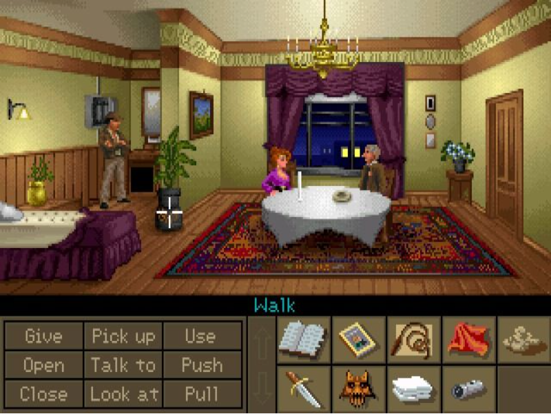 A screenshot from Indiana Jones and the Fate of Atlantic shows a séance, with Indy himself lurking at the side of the screen, in attractive pixel art. The interface has a box of nine verbs, and an inventory list in which each object gets its own graphical icon.